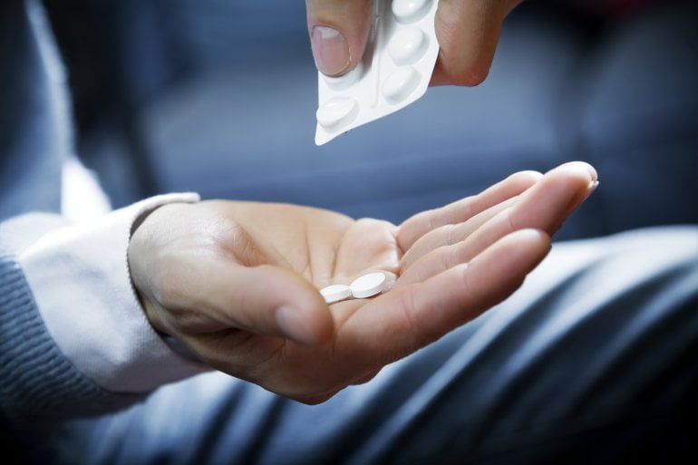 Ein Mann gibt Clenbuterol-Tabletten aus dem Blister in seine Hand