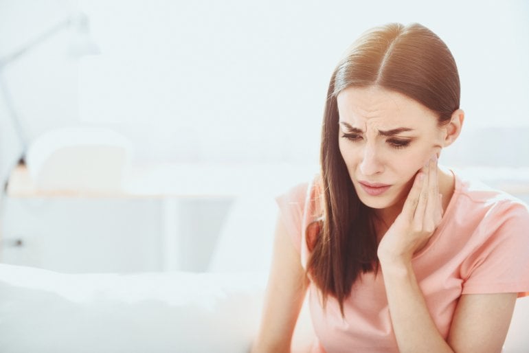 Frau leidet an Kieferschmerzen durch CMD