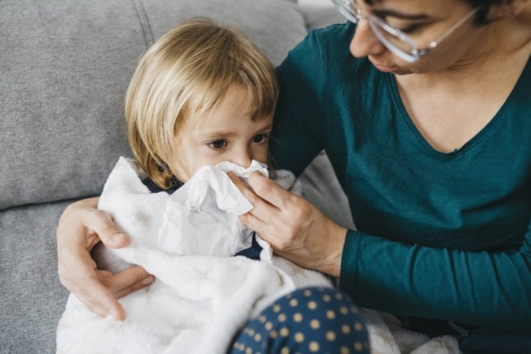 Krankes Kind mit RSV-Infektion putzt Nase