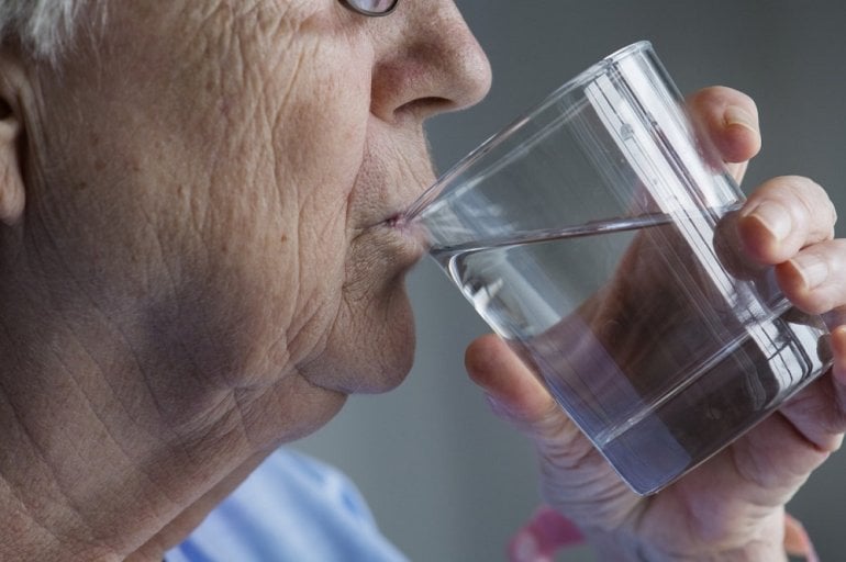 Frau mit trockenem Mund trinkt Wasser