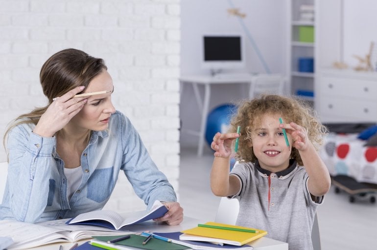 Kind mit ADHS abgelenkt beim Lernen mit seiner Mutter