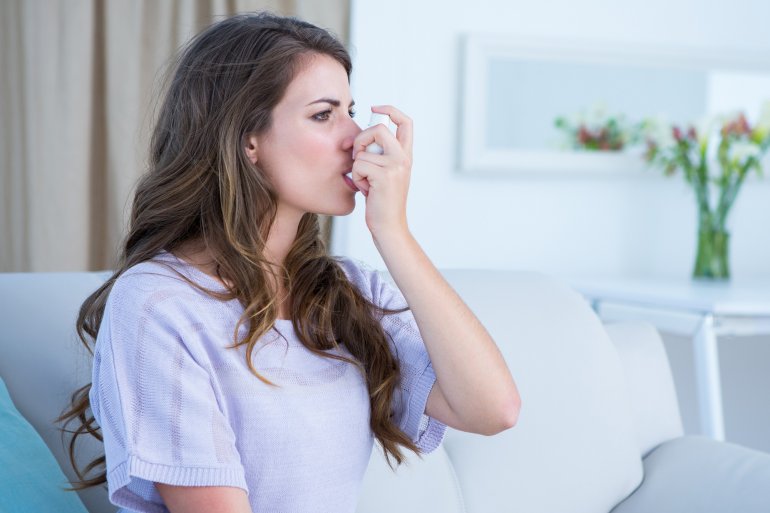 Frau mit Asthma bronchiale benutzt Inhalator mit Asthma-Spray