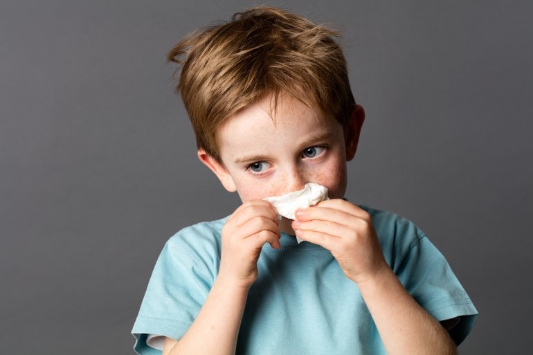 Kind mit Allergie putzt seine Nase