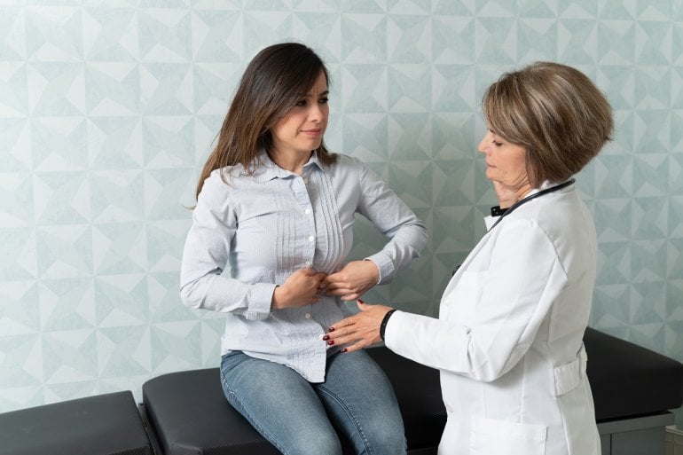 Ärztin untersucht Frau mit Bauchschmerzen