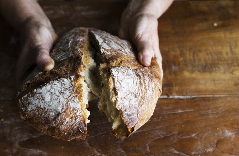 Hände halten einen Laib Brot