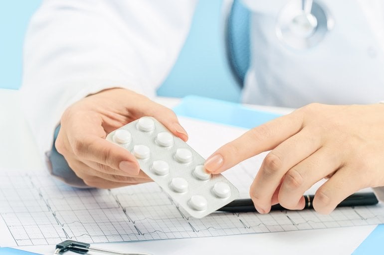 Ärztin hält eine Packung Cotrimoxazol-Tabletten