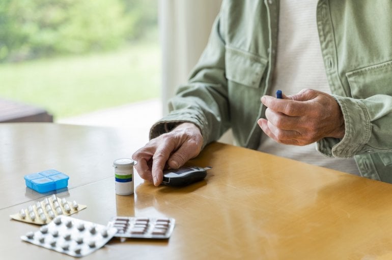 Mann mit Test und Tabletten für Diabetes