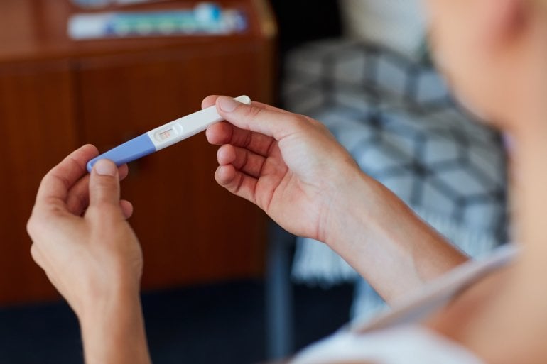 Frau misst HCG-Wert mit Schwangerschaftstest