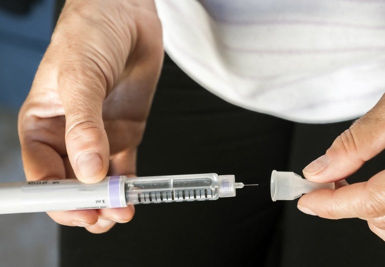 Frau wechselt Insulinpen-Nadel
