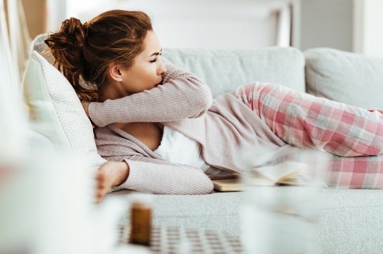 Frau mit Keuchhusten auf der Couch