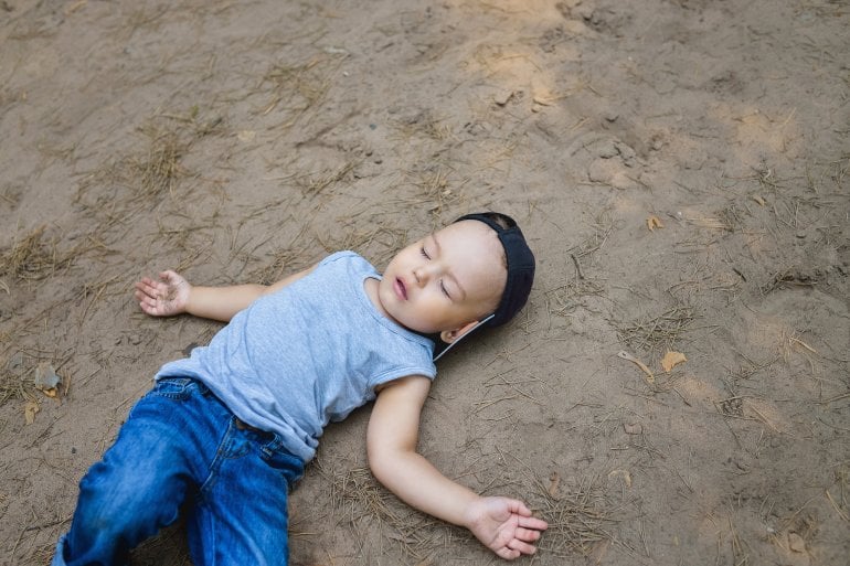 Kind mit Krampfanfall liegt am Boden