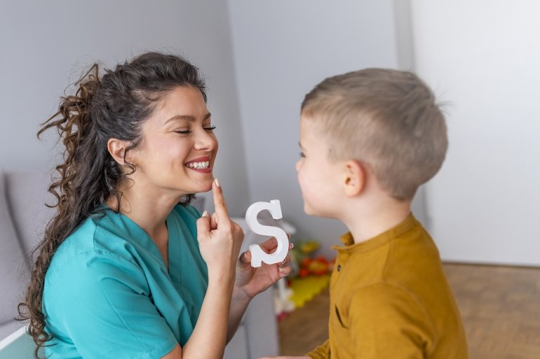 Logopädin übt Sprechen mit einem Kind