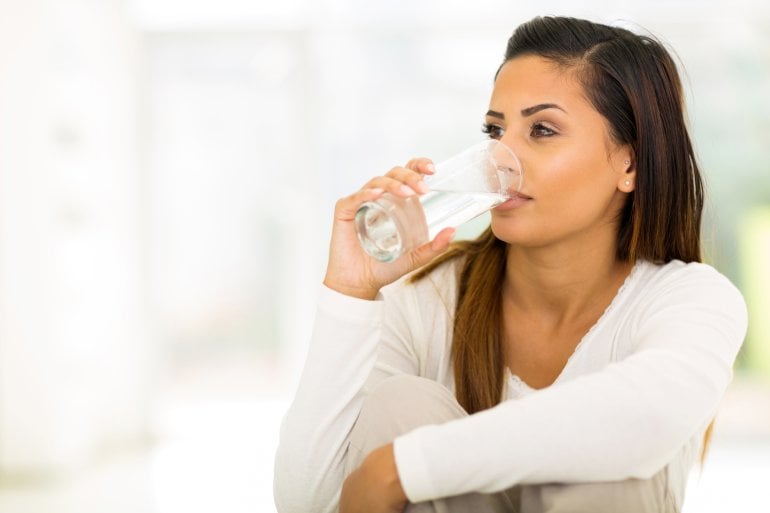 Schwangere Frau trinkt Wasser