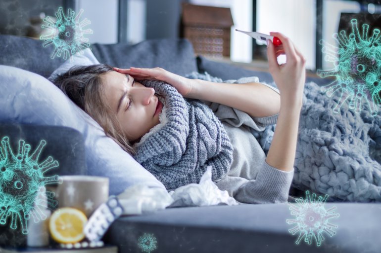 Frau misst Fieber auf dem Sofa