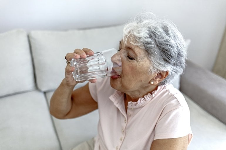 Frau trinkt viel Wasser als Anzeichen für Diabetes