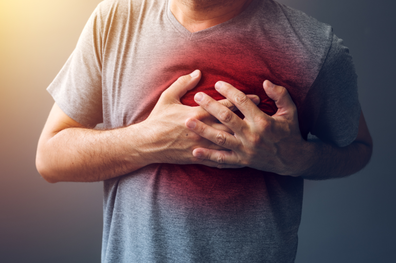 Mann mit Herzinfarkt greift sich an Brust