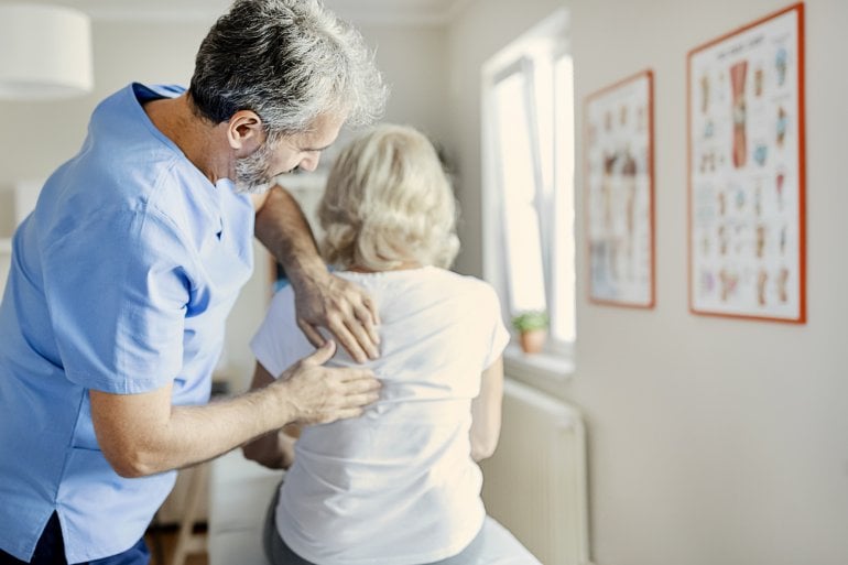 Arzt untersucht Frau mit Osteoporose-Risiko