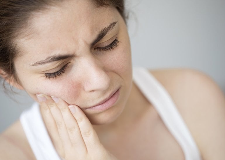 Frau mit Trigeminusneuralgie fasst sich in schmerzendes Gesicht