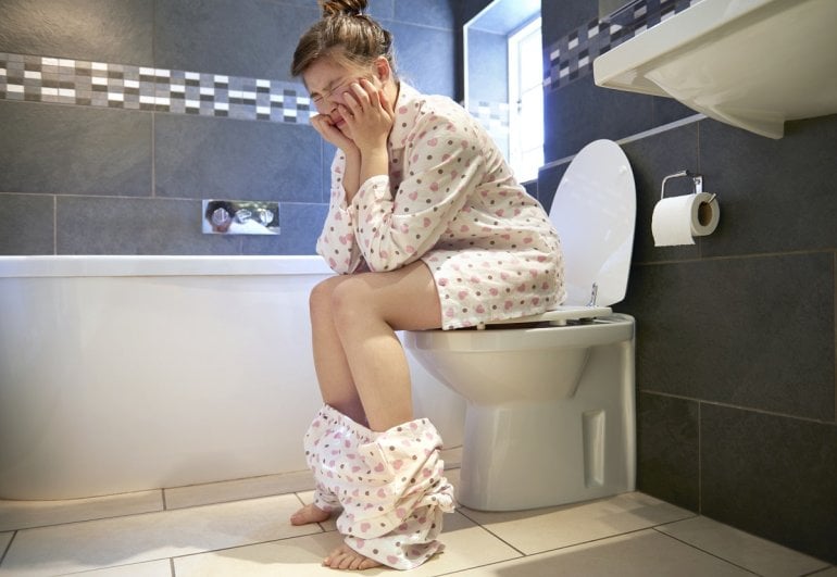 Frau mit Verstopfung auf Toilette