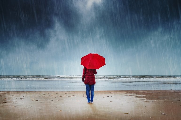 Wetterfühlige Frau mit Regenschirm