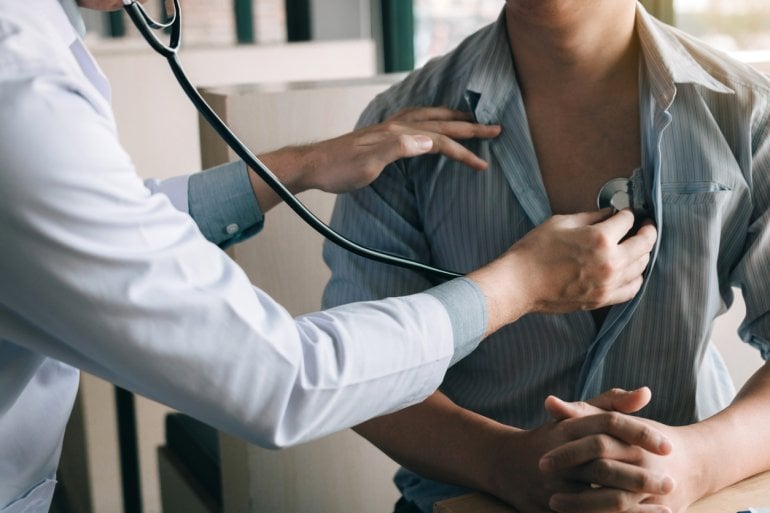 Ärztin hört Patienten mit Stethoskop ab