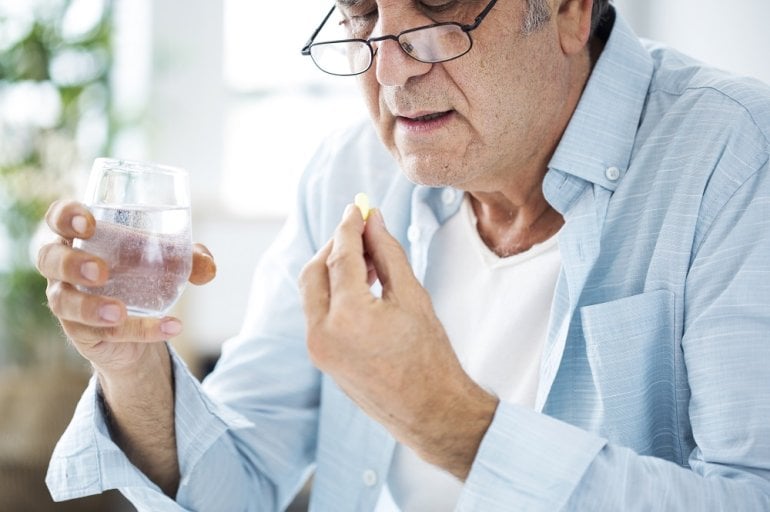 Mann mit Bluthochdruck hält Valsartan-Tablette